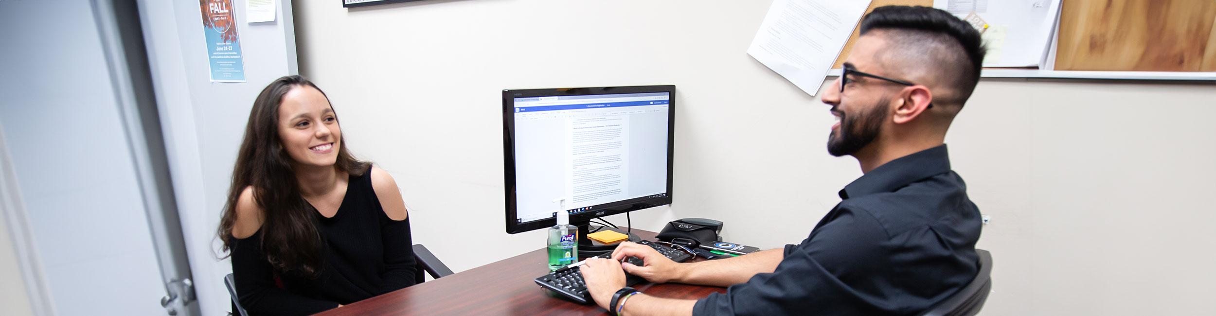 A student talking with Alexander College staff